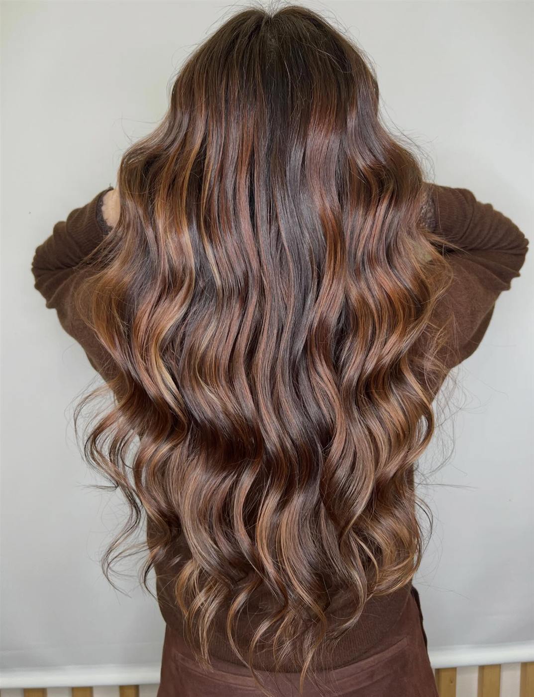 Castano scuro con balayage caramello, onde profonde viste da dietro